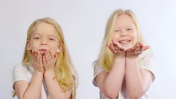 Caucasian Twins Blowing Kisses at Camera