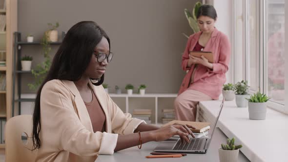 Two Young Diverse Businesswomen Working in Office