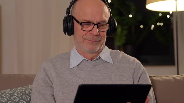 Senior Man with Tablet Pc and Headphones at Home