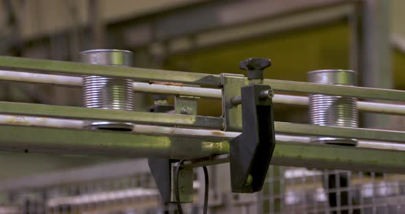 Aluminum canse down a conveyor belt on a factory food production line.