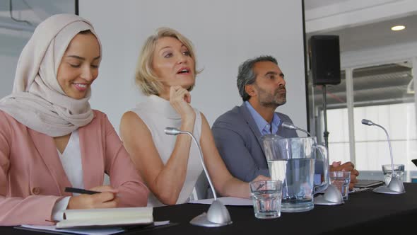 A panel of business delegates talking at a conference