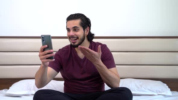 Happy Indian man talking to somebody on a video call