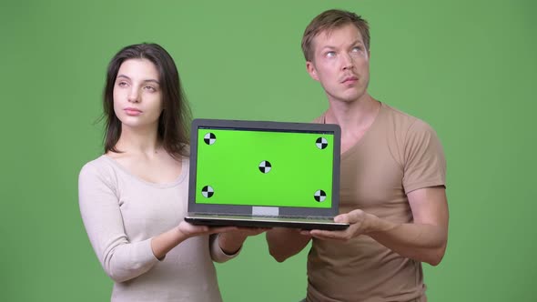 Young Couple Showing Laptop and Thinking Together