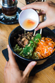 Pouring sour sauce on a colorful salad with fried pork - PhotoDune Item for Sale