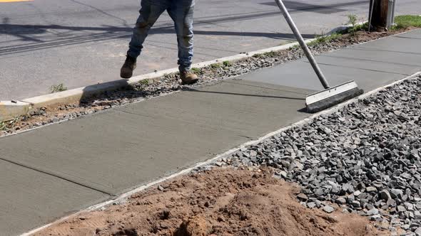 Workmen Finish and Smooth Concrete Surface on New Cement Sidewal