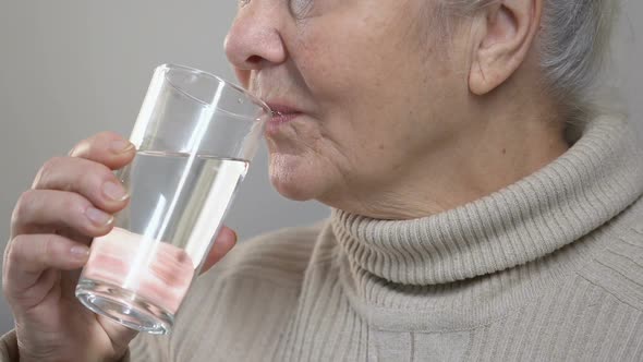 Wrinkled Elderly Woman Drinking Water, Feeling Thirsty, Taking Medicine, Closeup