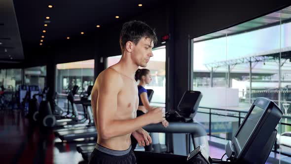 Male and female running on a treadmill at gym