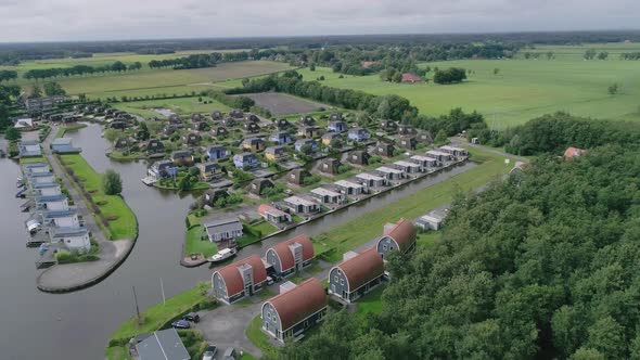 Wide Aerial of Small Dutch Holiday Park during Summer with Different Kind of Houses and Countryside