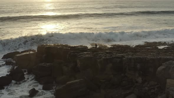 4k footage - Aerial / drone view of a surf surfer trying to get on water on a dangerous place. Surfe