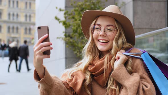 Attractive Girl Blogger Shoots Video for Blog After Shopping Standing on Street in City Caucasian