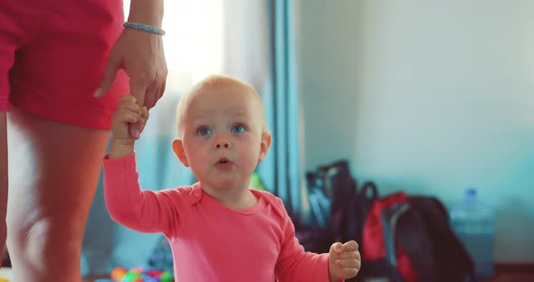 Little Child Walks with the Mother at the Apartment By the Hand