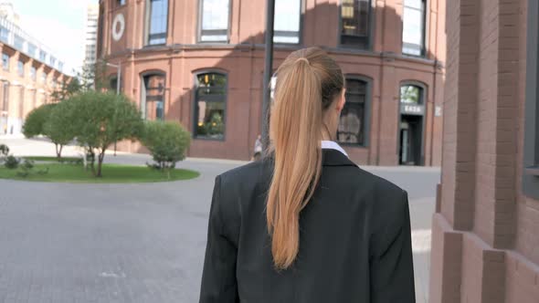 Back View of Businesswoman Walking Ouside Office