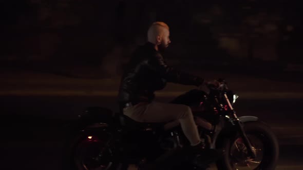 Side View of a Biker in Leather Jacket Riding Motobike By Night City Street