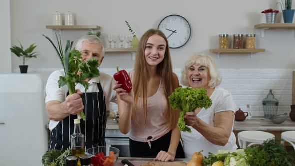 Girl with Mature Man and Woman Recommending Eating Raw Vegetable Food. Healthy Nutrition Diet