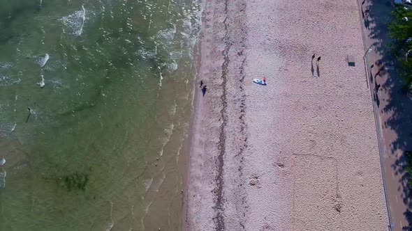 Drone panning up from beach to looking at coast line.