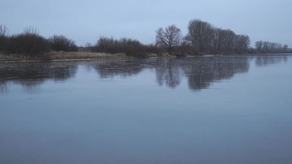 View of a Frozen Winter Lake with a Mirror Reflection on the Ice