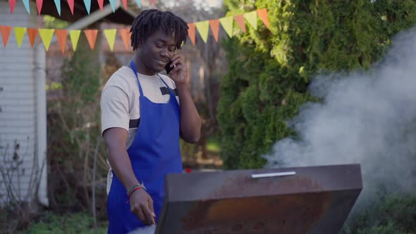 Live Camera Approaches in Slow Motion to Laughing Handsome Young African American Man in Apron