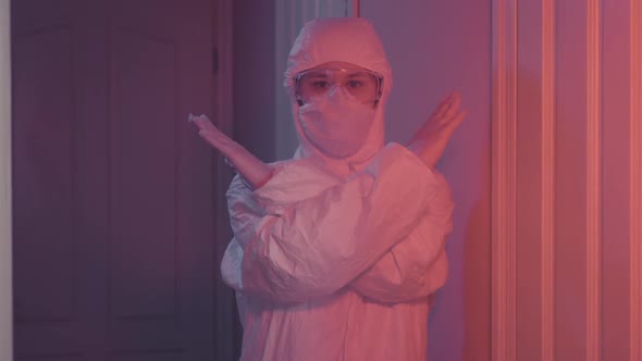 Caucasian Woman in Protective Suit Showing No Crossing Hands Sign