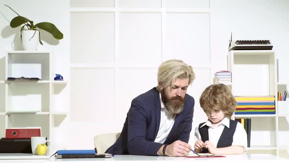 Businessman Father with His Son Drawing on Business Papers at Office