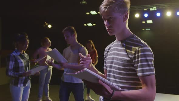 Students preparing before a high school performance in an empty school theater