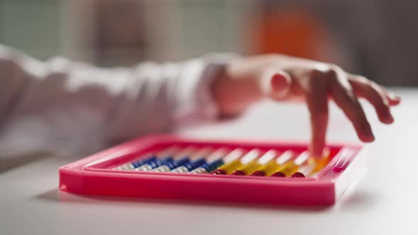 Little Girl Hand Counts Moving Small Beads on Toy Abacus