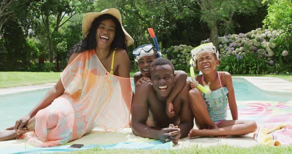 Happy african american family with beach equipment posing to photo at pool