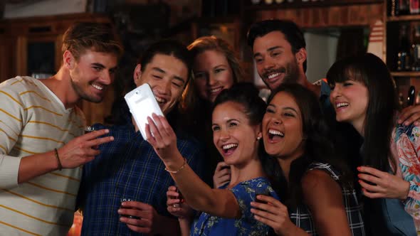 Group of friends taking selfie on mobile phone