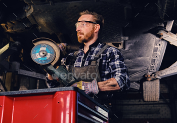 grinder near the car in a workshop.