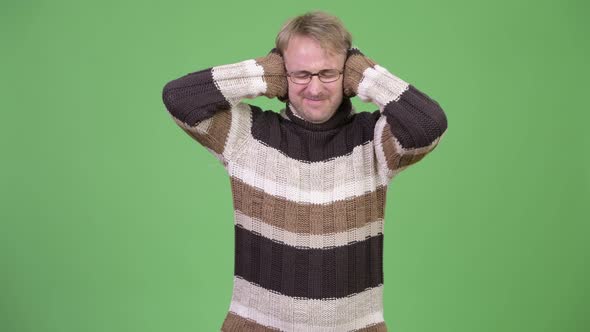 Studio Shot of Stressed Man Covering Ears From Loud Noise