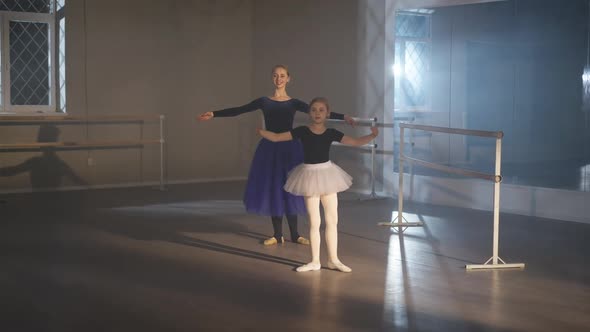 Wide Shot of Motivated Charming Pretty Little Ballerina and Gorgeous Woman Rehearsing Tendu Eleve