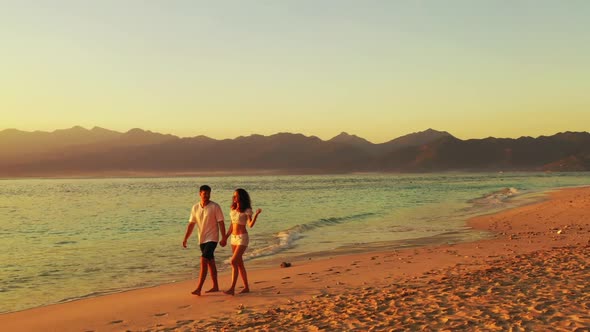 Teenage lovers in love on exotic sea view beach break by turquoise ocean and white sandy background 