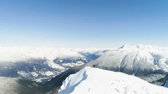 Skiers standing on a snow capped mountain 4k