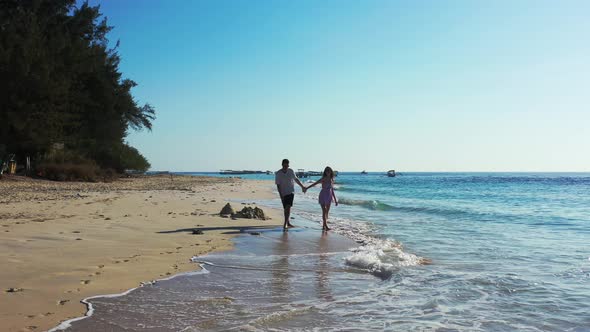 Romantic walk around the Bermuda island. Beautiful sandy beach and the couple enjoying honeymoon vac