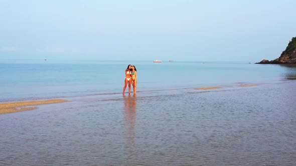 Ladies together happy together on marine tourist beach break by aqua blue lagoon and white sandy bac