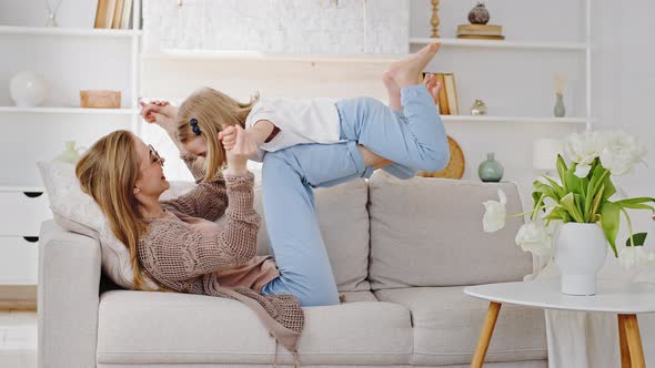 Happy Beautiful Family Young Blonde Mum Lifting Cute Little Child Daughter Kid Up Playing Plane on