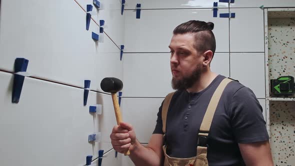 Tiler Knocks the Wedges of the Ceramic Tile Leveling System Off the Wall in the Bathroom Slow Motion