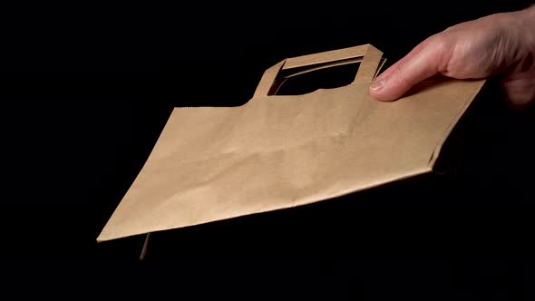 Male hand gives a paper package 