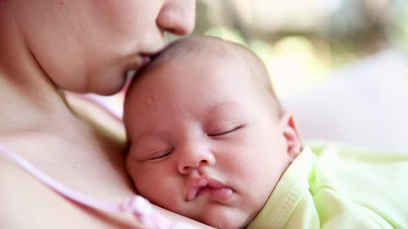 Little Baby Boy Sleeping on Mom's Chest Outdoor