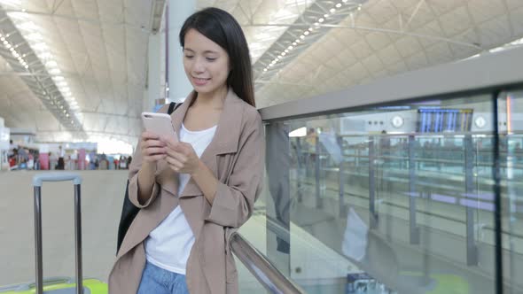 Woman working on cellphone in Hong Kong international airport 