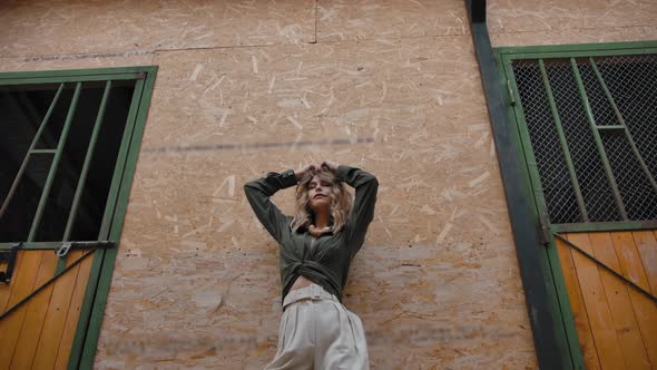 Slim Woman Standing Near Barn Wall