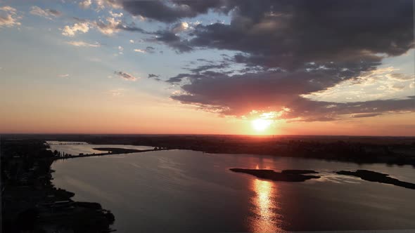 Descending on a golden sunrise reflecting on Moses Lake, Washington, aerial