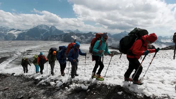 Young climbers moving up on a mountain slope one by one in a row