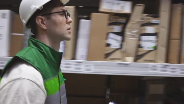 Young Warehouse Worker Check Quantity of Commodity in Big Market