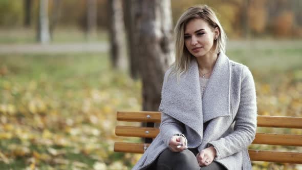 Young Beautiful Business Woman Smoking a Cigarette in the Park