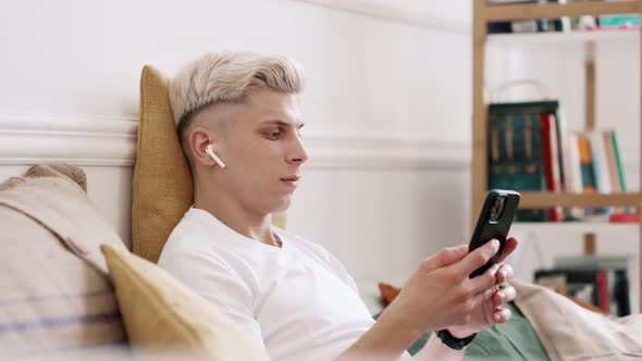 Young Man Using Smartphone and Headphones