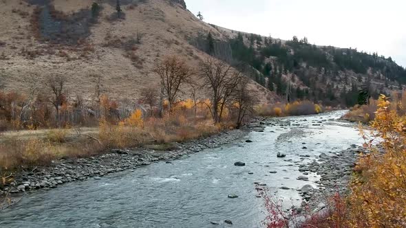 Ariel drone footage of a rugged river valley in fall.