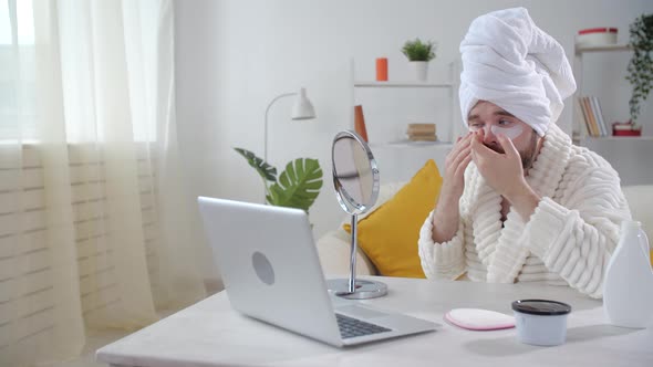 Skin Treatment and Selfcare Concept. Smiling Young Man Applying Eye Mask at Home