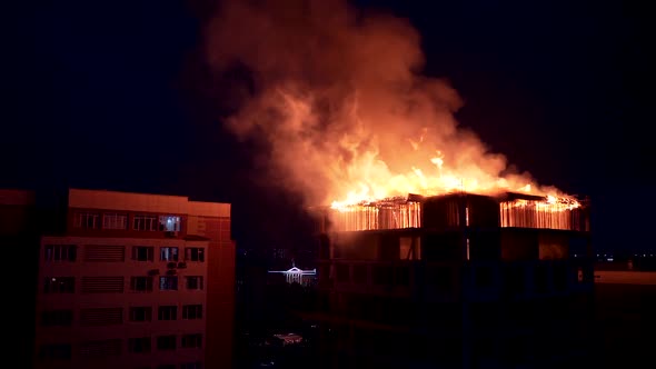 Slow motion burning fire flame on residential building roof at night