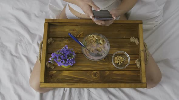 Woman Using Mobile Phone During Breakfast