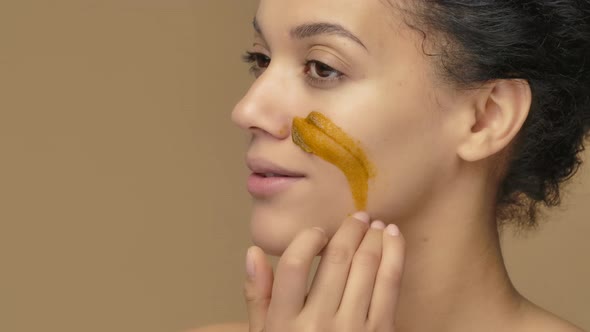 Beauty Portrait Young African American Woman Applying Skincare Scrub on Face Rubbing Gently with